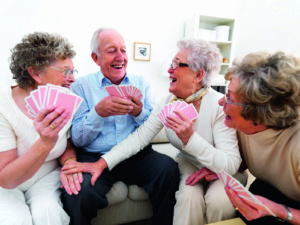 A group of happy elderly people enjoying themselves over a card game